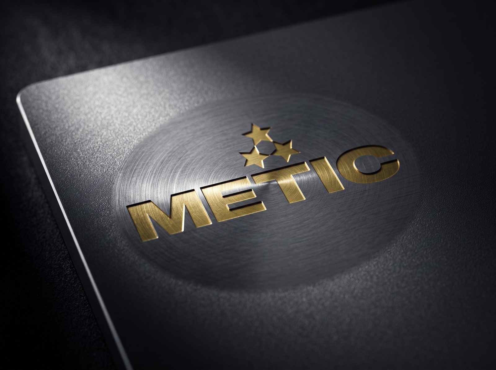 Metic zīme zeltā, kodināta tumšā metāla virsmā